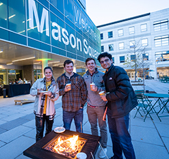 Students smiling next to a firepit. Links to Gifts of Cash, Checks, and Credit Cards
