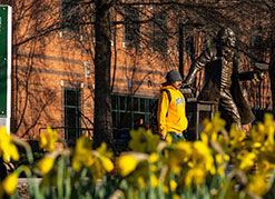 A student walking past a statue. Link to Life Stage Gift Planner Over Age 65 Situations.